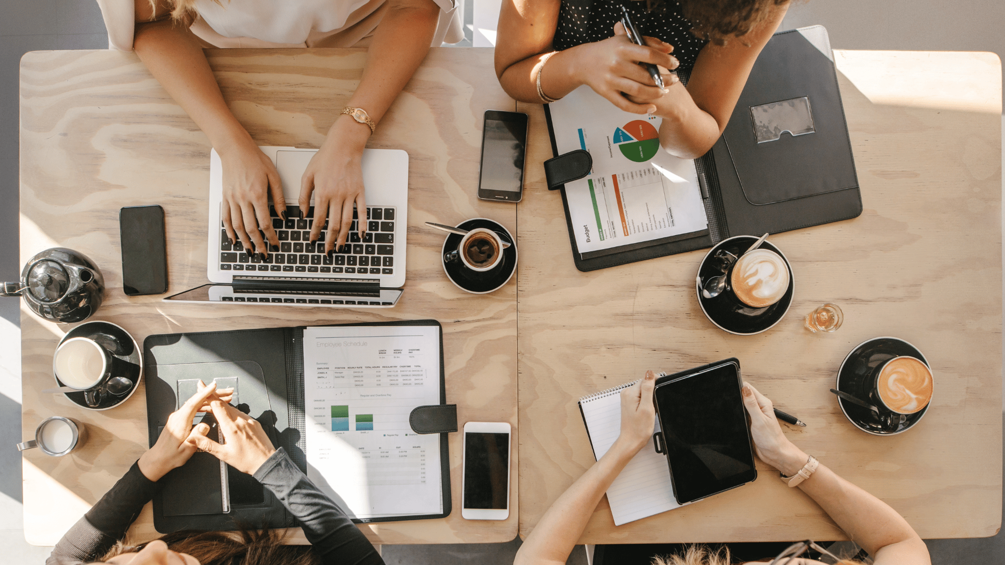 People planning around a table with tablets and laptops