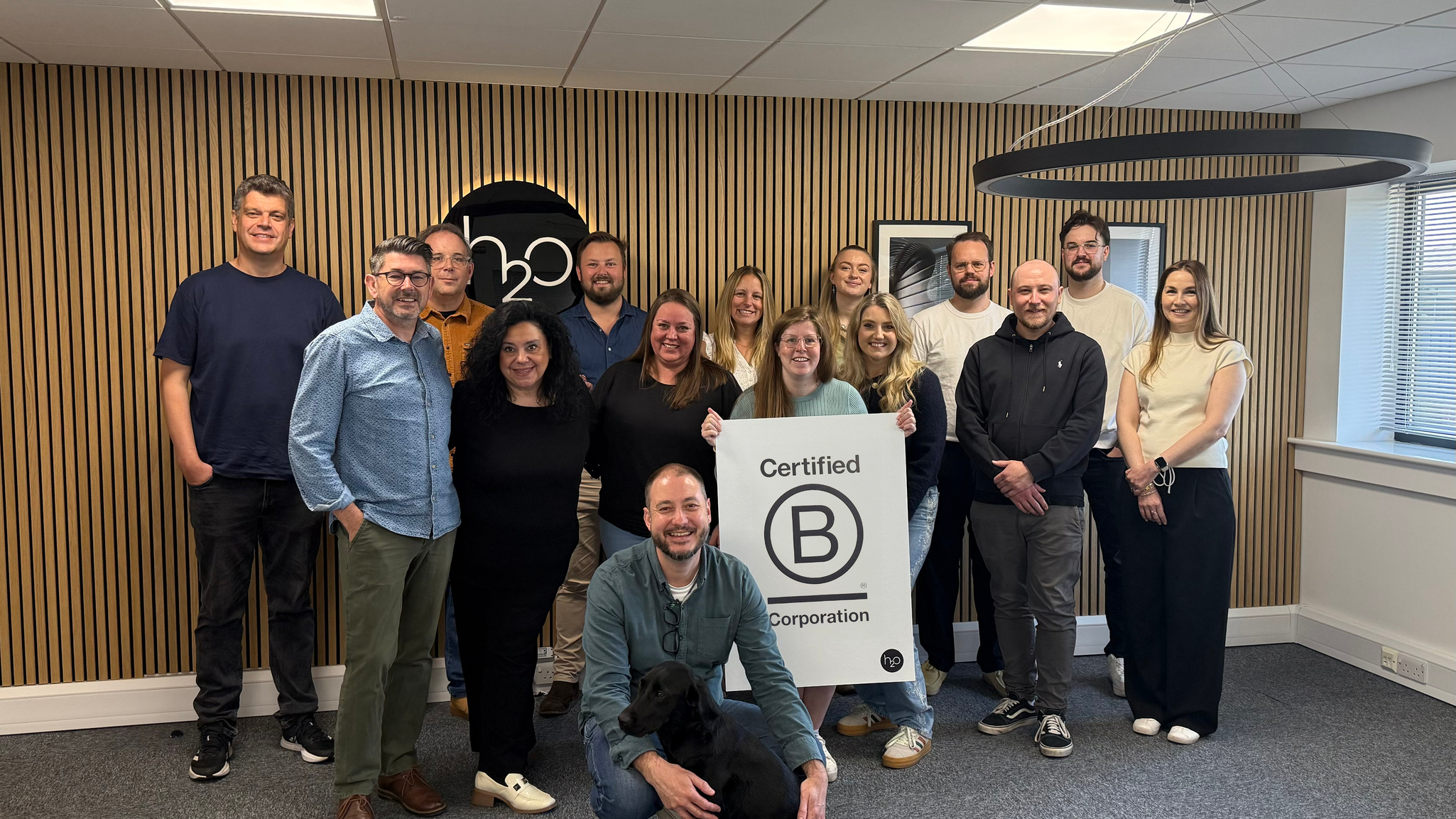 An Image of our team holding B Corp certified sign