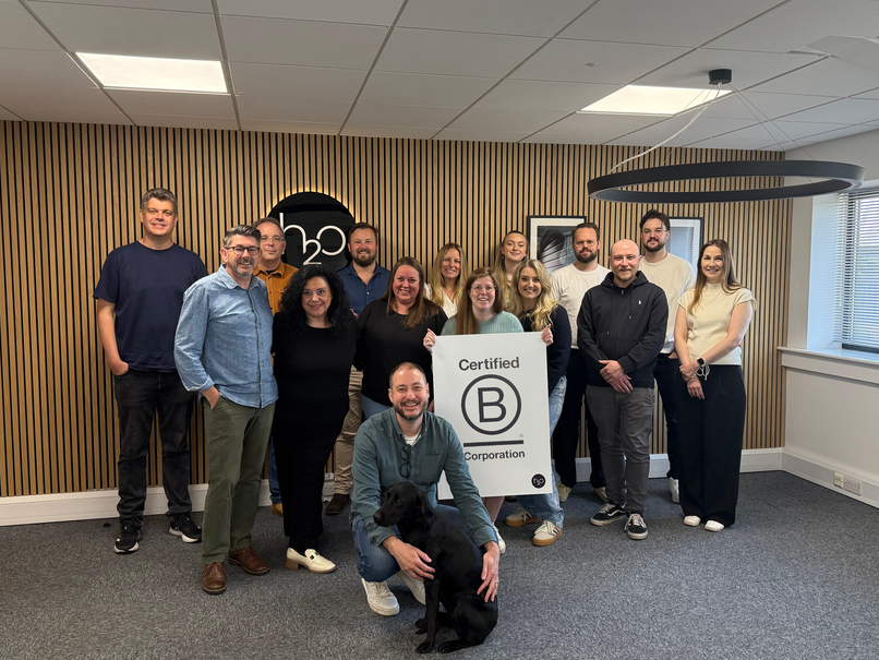 An Image of our team holding B Corp certified sign
