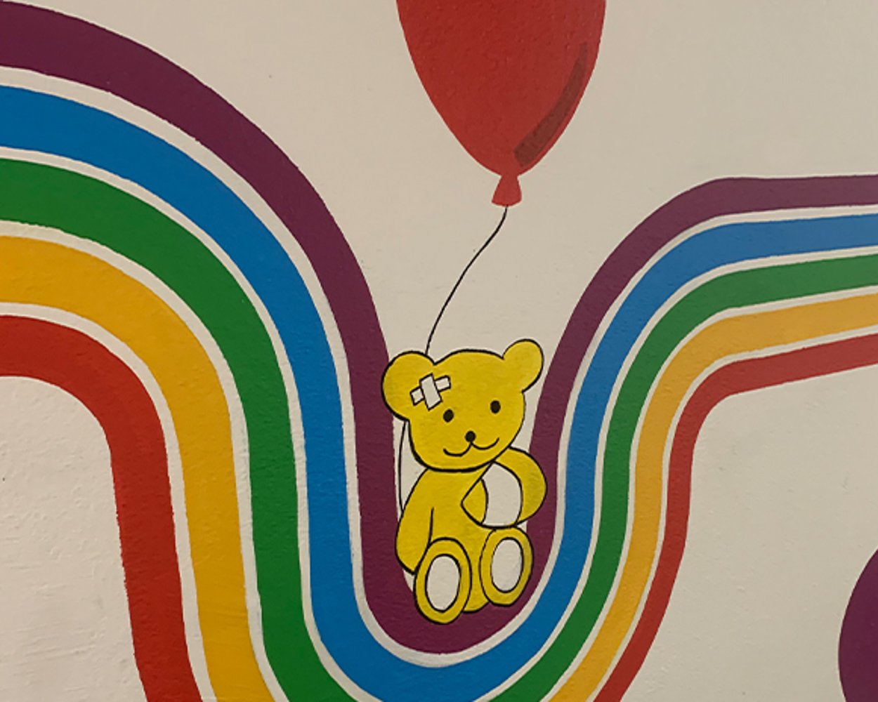 Image of the painted wall showing a teddy bear, rainbow and balloon