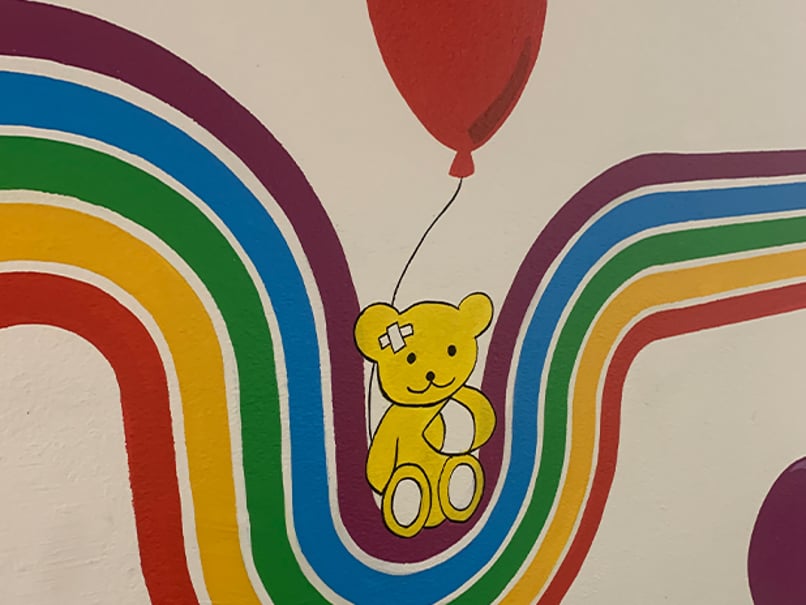 Image of the painted wall showing a teddy bear, rainbow and balloon