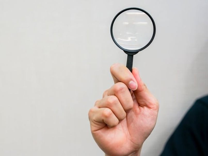 Showing a magnifying glass being help up 