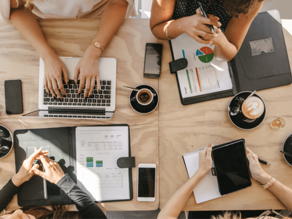 People planning around a table with tablets and laptops