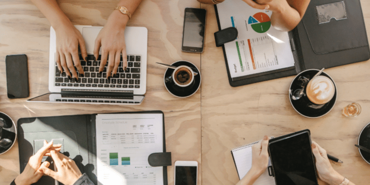 People planning around a table with tablets and laptops