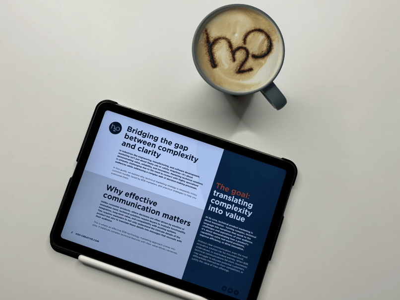 showing a page from our eBook 'why marketing technical solutions can be tricky' alongside a coffee with the h2o logo on it